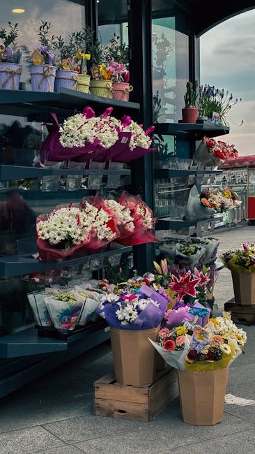 A display of various floral arrangements outside a florist near East Croydon station, featuring bouquets of fresh flowers including white, pink, purple, and yellow blooms. The arrangements are wrapped